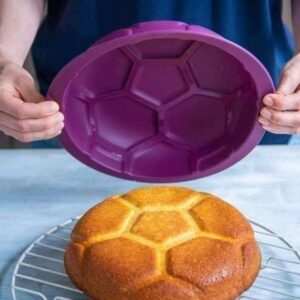 Silikoonist jalgpallimustriga küpsetusvorm ja sellest välja võetud kook